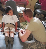 Cadet Patrick O’Donahue helps interpret for a young dental patient.
