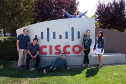 Santiago poses with other interns in front of the Cisco sign his sophomore year.