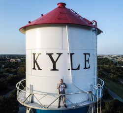 Sellers in front of Kyle, Texas, water tower