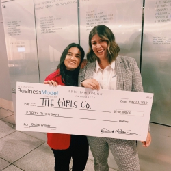 Zoia Ali and Taimi Kennerly pose with a $40,000 check after Girls Co. won the International Business Model Competition
