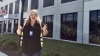 Nichole Rohrbaugh gives two thumbs up in front of large building that reads Amazon Fulfillment.