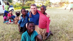 Eli Tucker plays with some local children on a study abroad trip to Africa