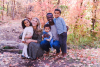 Nzojibwami and his wife and three children surrounded by fall leaves.